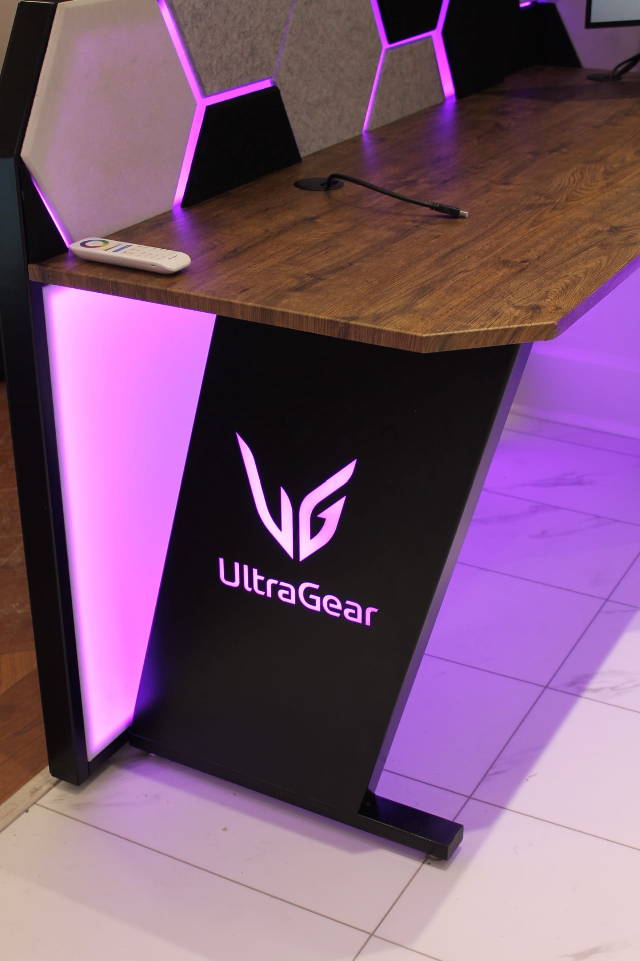 Detail of the UltraGear desk - powder-coated metal, wood work surface and magenta LED accent lighting