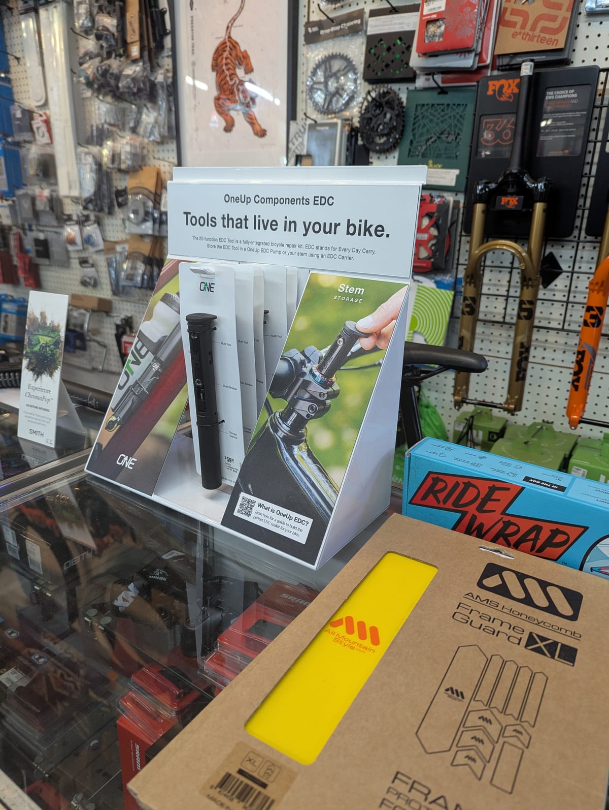 OneUp Components EDC counter display merchandising packaged components in a bike shop
