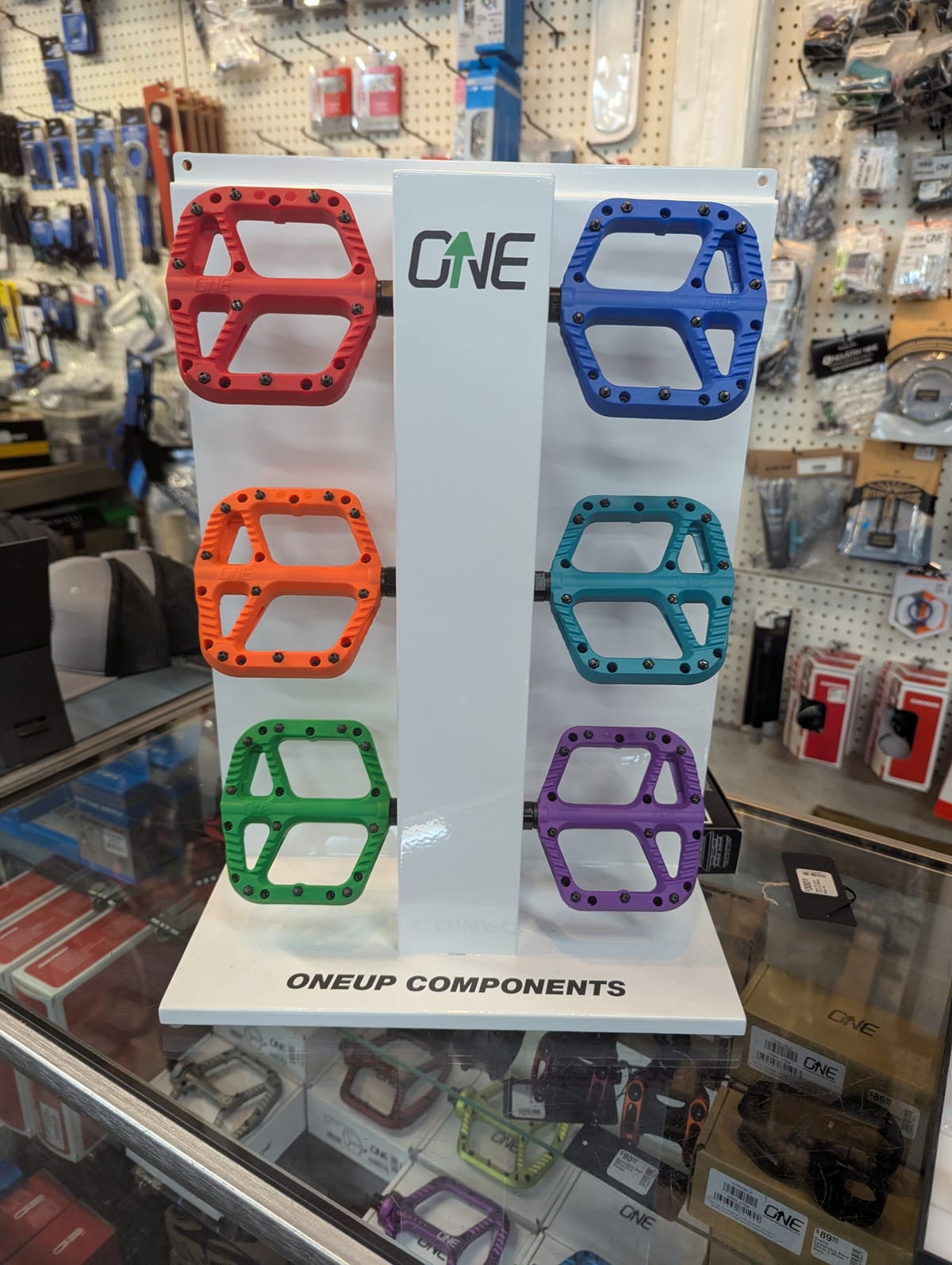 OneUp Components pedal counter display merchandised in a bike shop